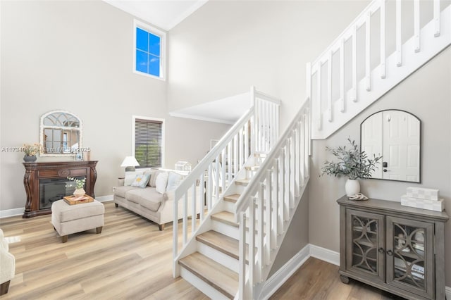 staircase featuring wood-type flooring and a towering ceiling