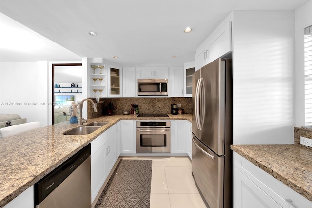 3750 NE 170th St Unit 101, North Miami Beach, FL 33160 - kitchen with appliances with stainless steel finishes, a sink, glass insert cabinets, light stone countertops, and white cabinetry