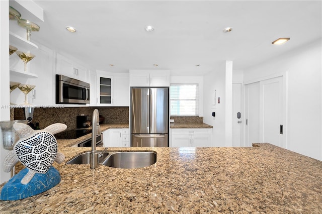 3750 NE 170th St Unit 101, North Miami Beach, FL 33160 - kitchen featuring appliances with stainless steel finishes, a sink, open shelves, dark stone counters, and white cabinets
