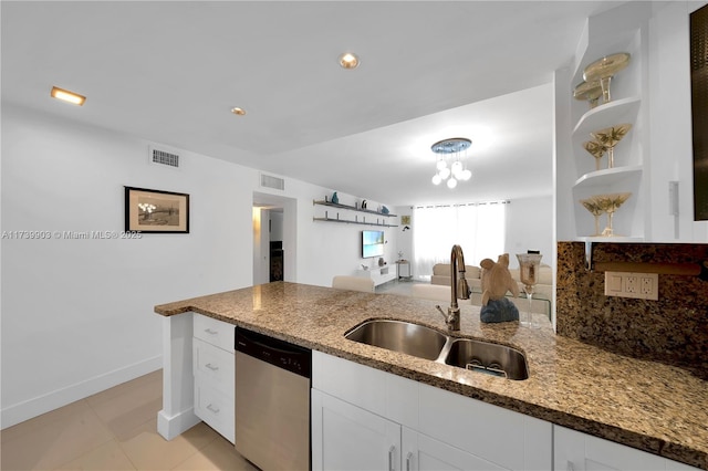 kitchen featuring white cabinetry, dishwasher, sink, dark stone counters, and light tile patterned floors