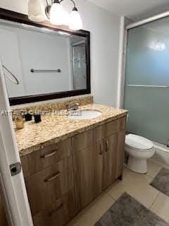 bathroom with vanity, toilet, tile patterned floors, and walk in shower