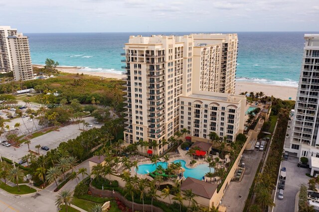 view of building exterior featuring a water view and a beach view