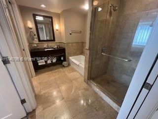 bathroom featuring tile patterned flooring, vanity, separate shower and tub, and tile walls