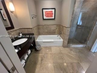 bathroom with vanity and separate shower and tub