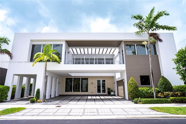 back of property with a balcony and stucco siding