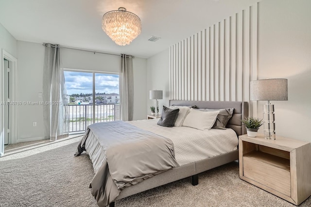 carpeted bedroom with a notable chandelier and access to exterior