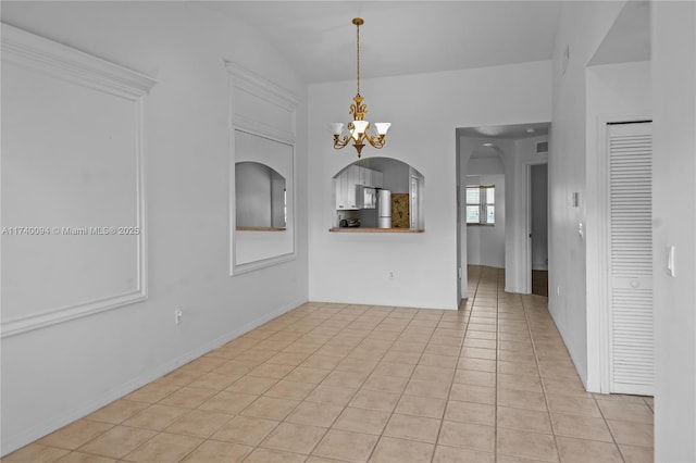 unfurnished dining area featuring light tile patterned floors and a notable chandelier