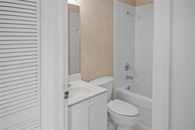full bathroom featuring vanity, tiled shower / bath, and toilet