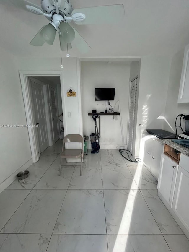 interior space featuring white cabinetry and ceiling fan