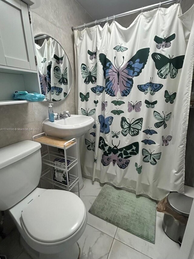 bathroom featuring shower / bath combination with curtain, tile walls, decorative backsplash, and toilet