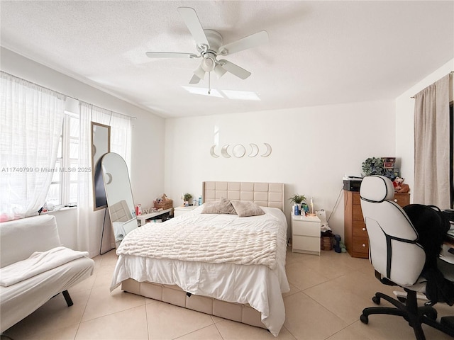 bedroom with ceiling fan, a textured ceiling, and light tile patterned floors