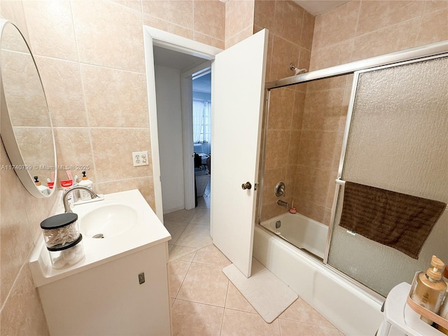 bathroom with vanity, combined bath / shower with glass door, tile walls, and tile patterned floors