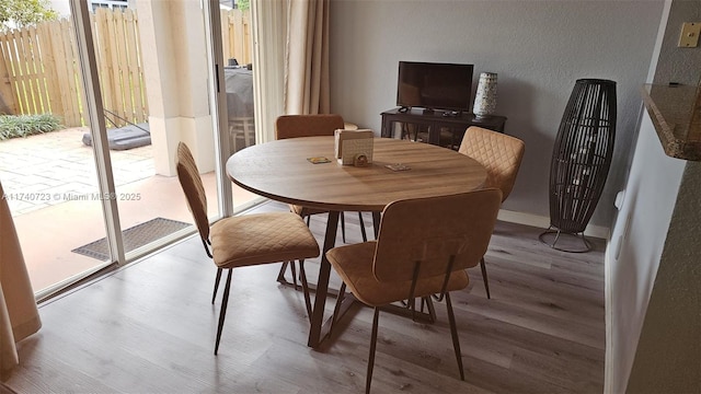 dining space with hardwood / wood-style floors and a wealth of natural light