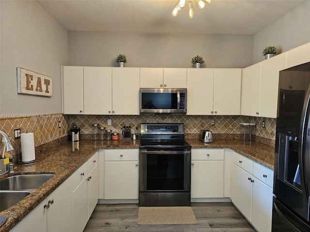 kitchen featuring sink, white cabinetry, black fridge, electric range oven, and dark hardwood / wood-style floors