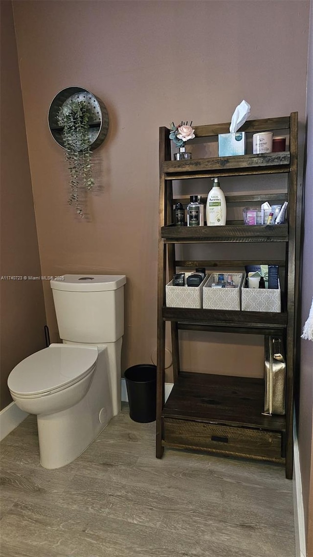 bathroom with hardwood / wood-style floors and toilet