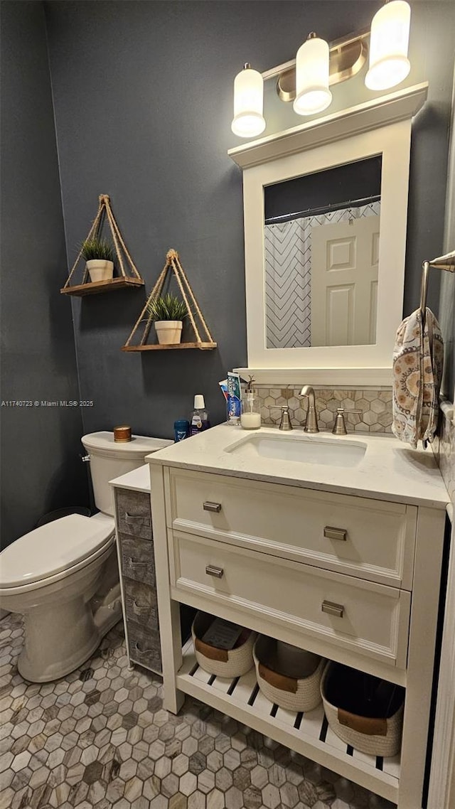 bathroom with vanity, backsplash, and toilet