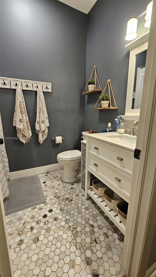 bathroom featuring vanity, tile patterned floors, and toilet