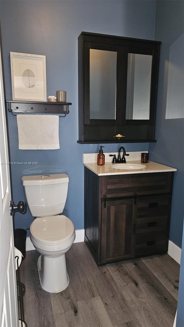 bathroom with vanity, hardwood / wood-style floors, and toilet