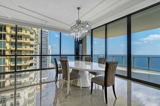 dining area with a notable chandelier, floor to ceiling windows, and a water view