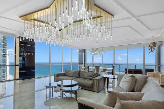 living room with a water view, a chandelier, and a wall of windows