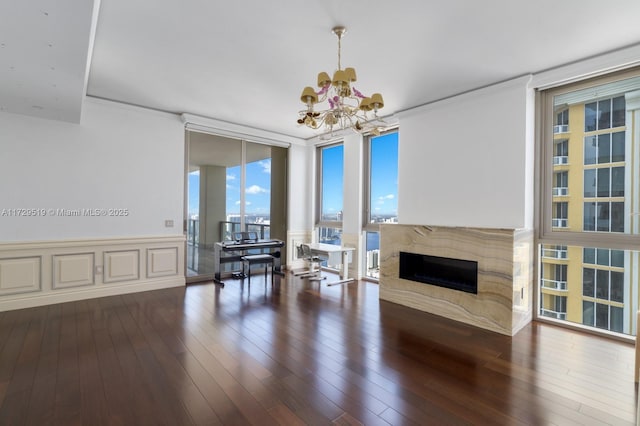 living room featuring a wall of windows, a high end fireplace, dark hardwood / wood-style floors, and a notable chandelier