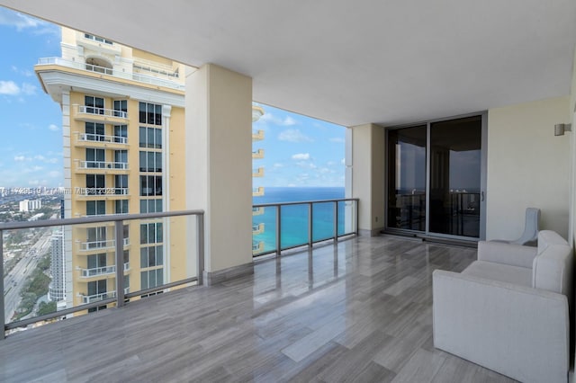 balcony with an outdoor living space and a water view