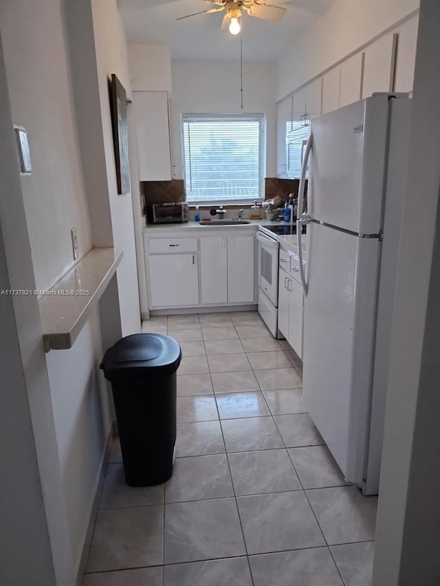 kitchen featuring light tile patterned floors, white cabinets, white appliances, and decorative backsplash