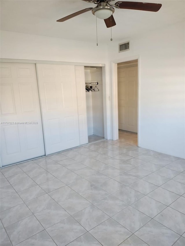 unfurnished bedroom with ceiling fan and a closet