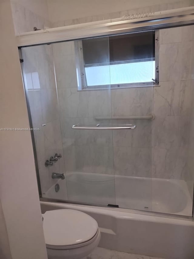 bathroom featuring a wealth of natural light, toilet, and combined bath / shower with glass door