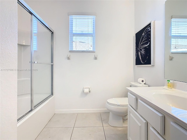 full bathroom featuring toilet, tile patterned floors, a healthy amount of sunlight, and bath / shower combo with glass door