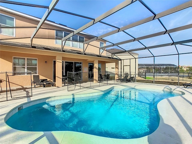 view of swimming pool featuring a lanai and a patio