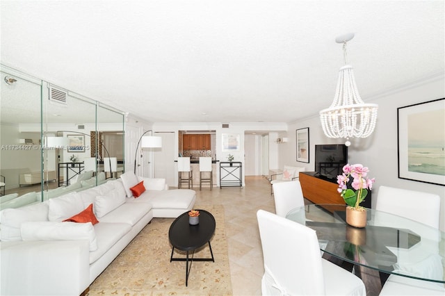 living room featuring an inviting chandelier, visible vents, and ornamental molding