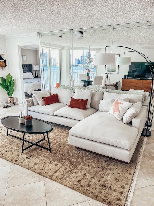 living room featuring a textured ceiling, ornamental molding, and tile patterned flooring