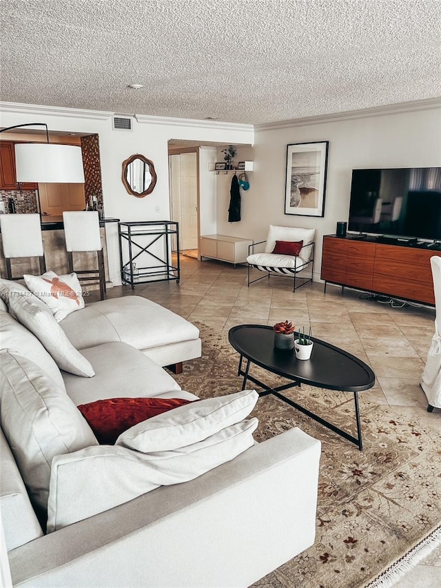 living room featuring tile patterned flooring, a textured ceiling, and ornamental molding