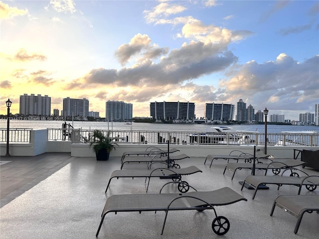 patio terrace at dusk featuring a water view