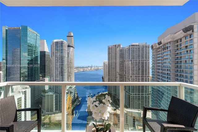 balcony featuring a water view and central AC unit