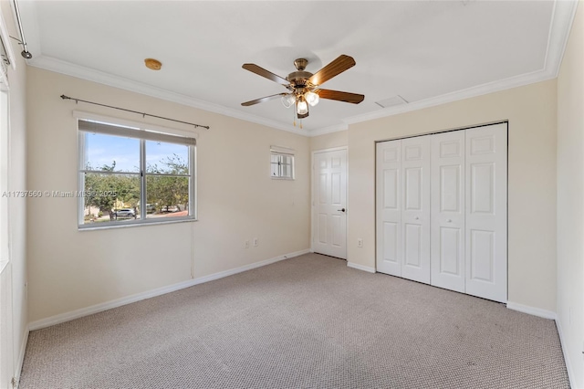 unfurnished bedroom featuring ornamental molding, light carpet, ceiling fan, and a closet