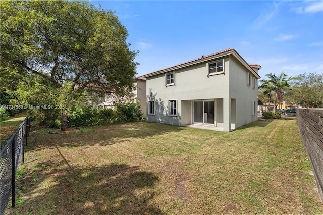 rear view of house featuring a lawn