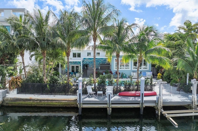 view of dock with boat lift, a water view, fence, and a pool