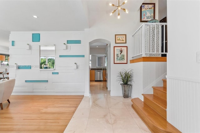 foyer entrance with arched walkways, recessed lighting, an inviting chandelier, and stairs