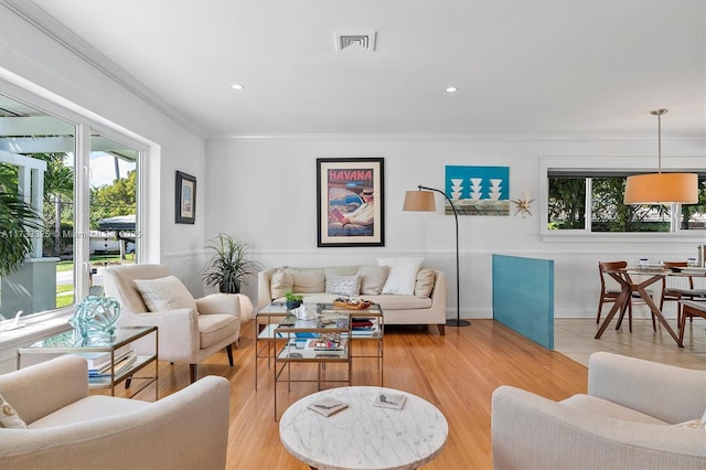 living room featuring light wood-style flooring, recessed lighting, visible vents, and crown molding