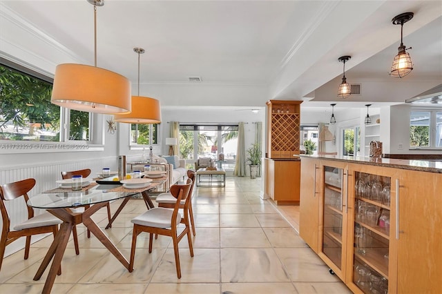 dining area with visible vents, beverage cooler, a wealth of natural light, and crown molding