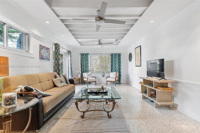 living room with speckled floor, wainscoting, a wealth of natural light, and recessed lighting