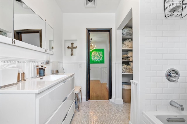 full bathroom featuring visible vents, wainscoting, tile patterned flooring, tub / shower combination, and vanity