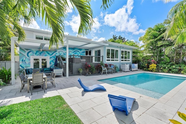 pool with outdoor lounge area, cooling unit, and a patio