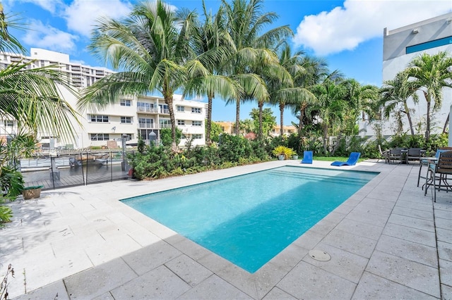 outdoor pool featuring a patio and fence