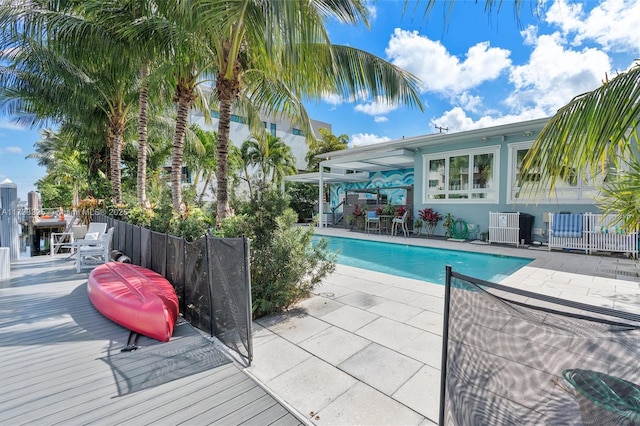 view of swimming pool featuring a patio area, fence, a fenced in pool, and central air condition unit