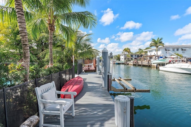 dock area featuring a water view, boat lift, and fence