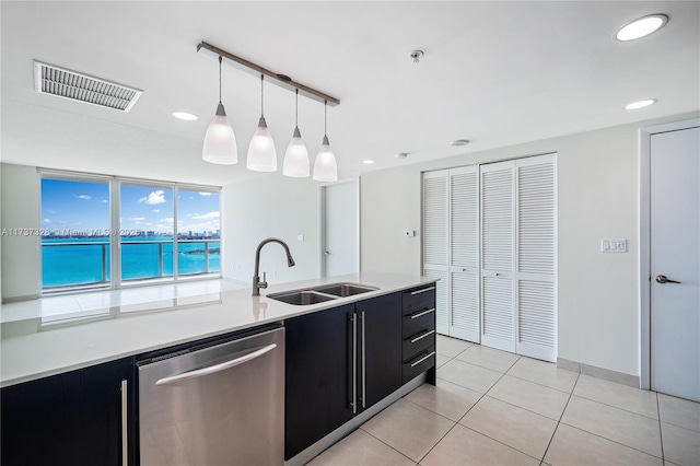 kitchen with a water view, dishwasher, decorative light fixtures, light tile patterned floors, and sink