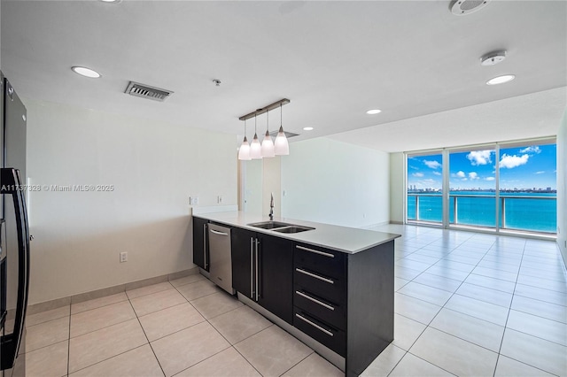 kitchen with sink, a water view, hanging light fixtures, kitchen peninsula, and dishwasher